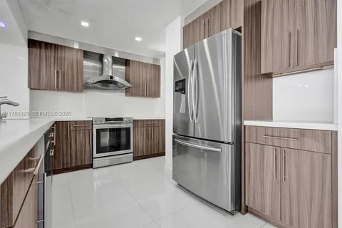 a kitchen with stainless steel appliances granite countertop a refrigerator stove and sink
