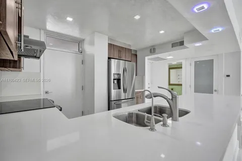 a kitchen with a refrigerator a sink and a cabinets