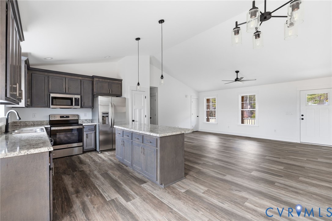 5245 Courtland Road Disputanta, VA 23842 - Photo 11 of 27 a kitchen with stainless steel appliances a stove top oven a sink with cabinets and wooden floor