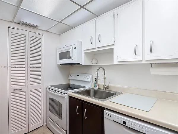 a kitchen with stainless steel appliances granite countertop a sink and a stove