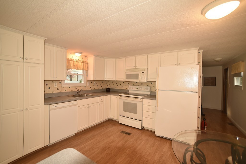 154 Windswept Road Wareham, MA 02576 - Photo 8 of 16 a kitchen with granite countertop white cabinets and white appliances