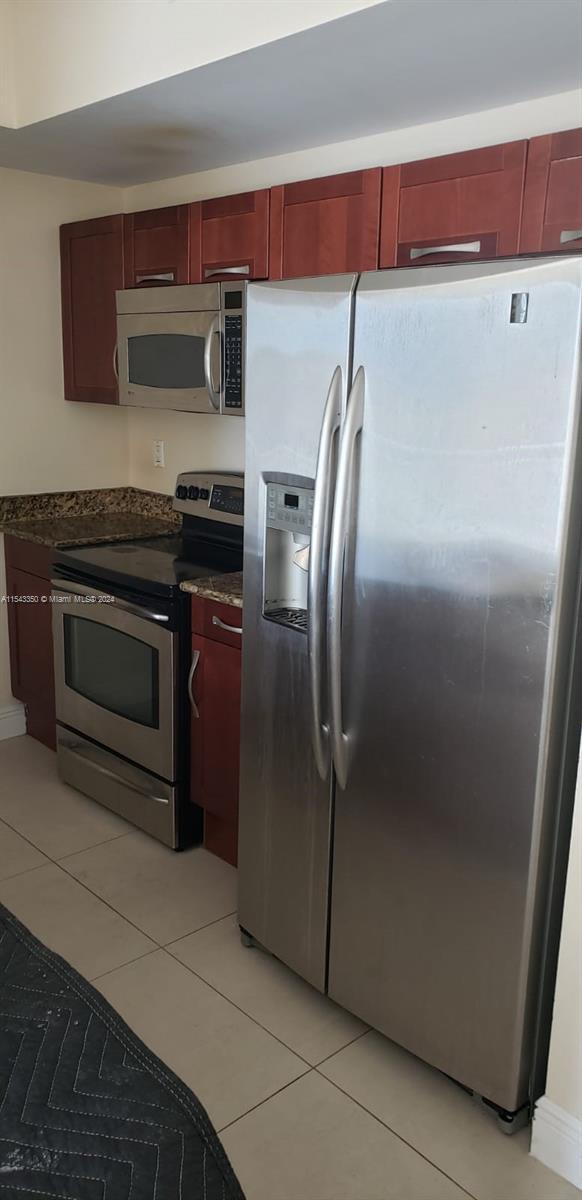 a metallic refrigerator freezer sitting in a kitchen