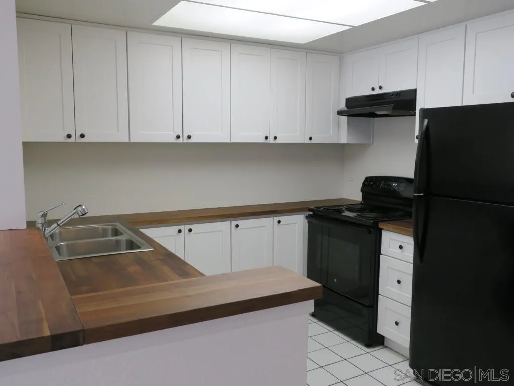 5938 Rancho Mission Road, Unit 134 San Diego, CA 92108 - Photo 1 of 36 a kitchen with a refrigerator and cabinets