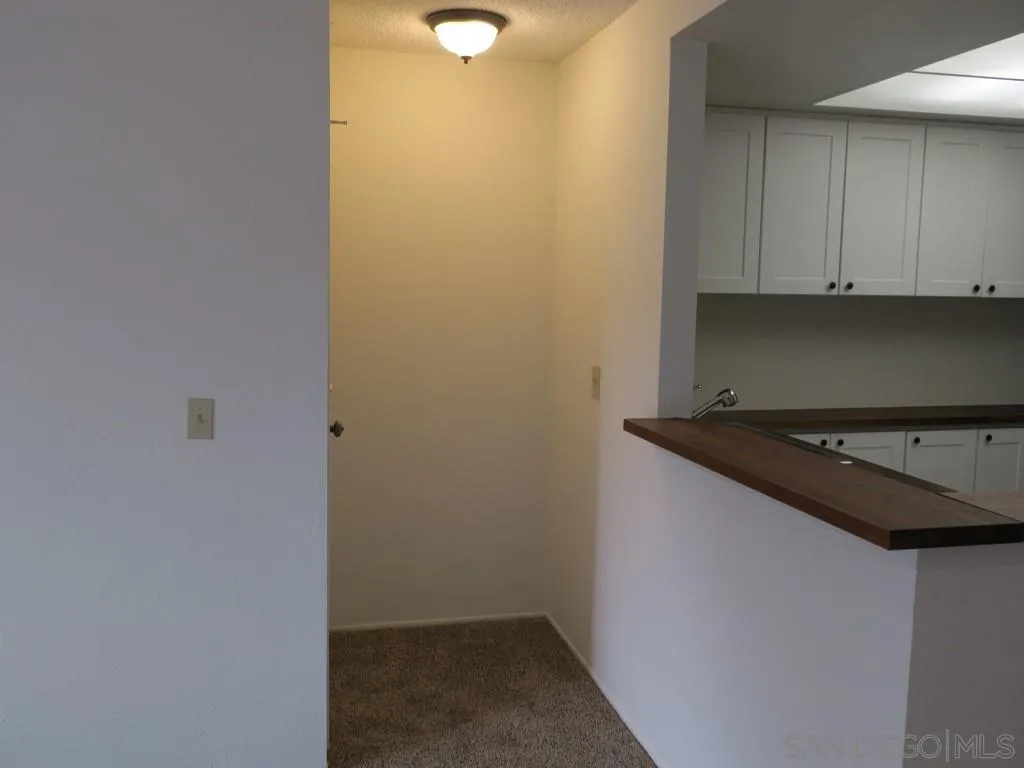 5938 Rancho Mission Road, Unit 134 San Diego, CA 92108 - Photo 6 of 36 a view of a refrigerator and cabinets