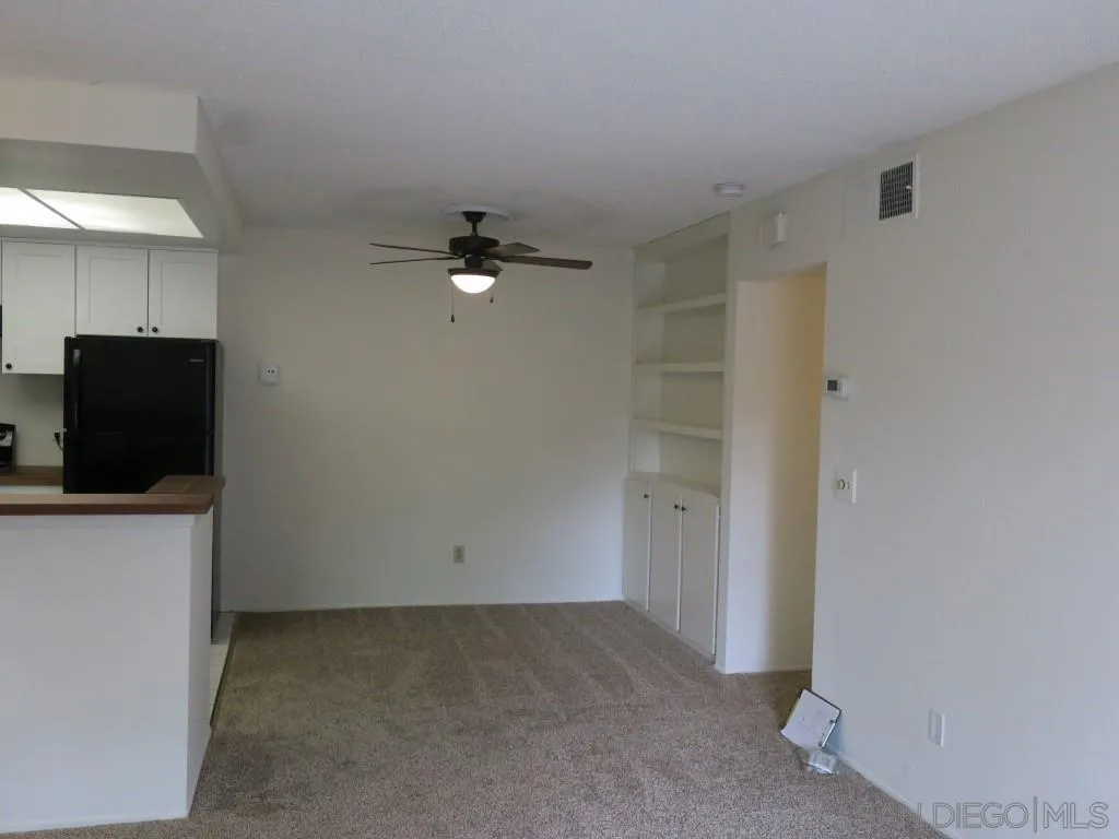 5938 Rancho Mission Road, Unit 134 San Diego, CA 92108 - Photo 8 of 36 a view of an empty room with a fireplace and cabinet