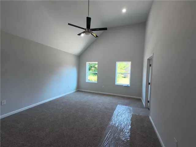 en empty room with windows and ceiling fan