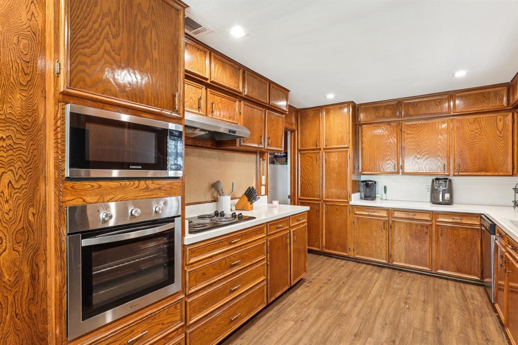 6667 Silver Saddle Road Fort Worth, TX 76126 - Photo 14 of 35 a kitchen with stainless steel appliances a stove a sink and a microwave