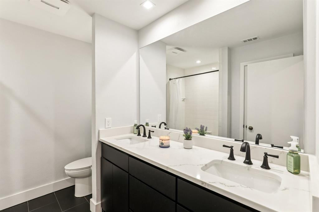 6667 Silver Saddle Road Fort Worth, TX 76126 - Photo 22 of 35 a bathroom with a double vanity sink toilet and a mirror