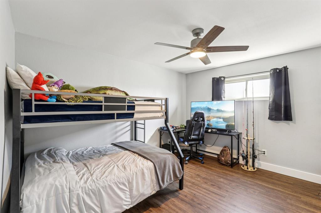 6667 Silver Saddle Road Fort Worth, TX 76126 - Photo 24 of 35 a bedroom with a bed and wooden floor