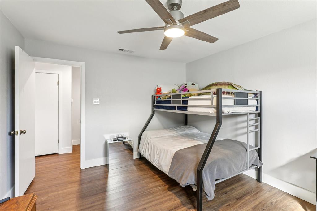 6667 Silver Saddle Road Fort Worth, TX 76126 - Photo 25 of 35 a bedroom with a bed and a chandelier