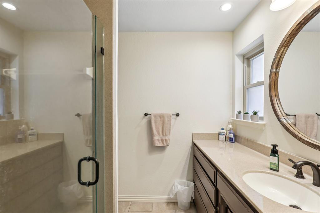 6667 Silver Saddle Road Fort Worth, TX 76126 - Photo 26 of 35 a bathroom with a granite countertop sink a mirror and shower