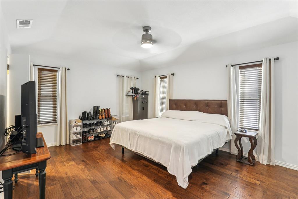 6667 Silver Saddle Road Fort Worth, TX 76126 - Photo 27 of 35 a bedroom with a bed and wooden floor