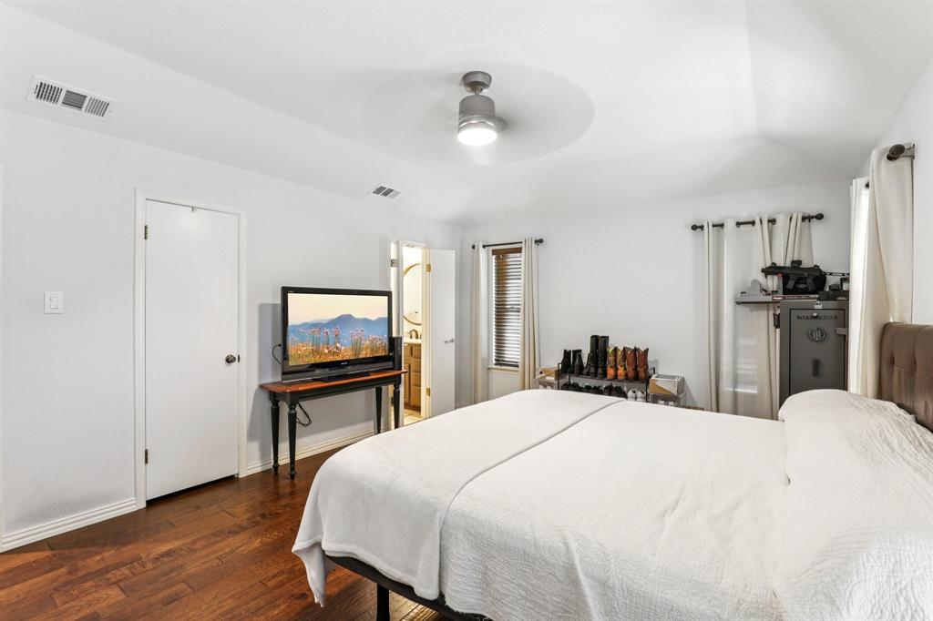 6667 Silver Saddle Road Fort Worth, TX 76126 - Photo 28 of 35 a bedroom with a bed and a flat screen tv