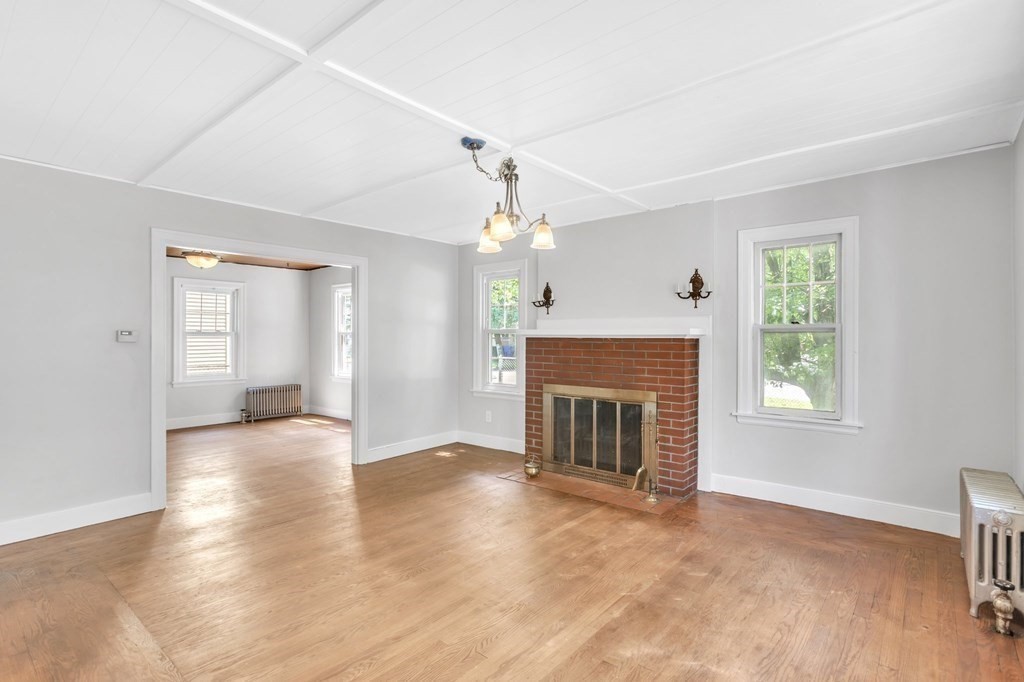 61 Beauregard Street Springfield, MA 01151 - Photo 3 of 24 an empty room with windows fireplace and wooden floor