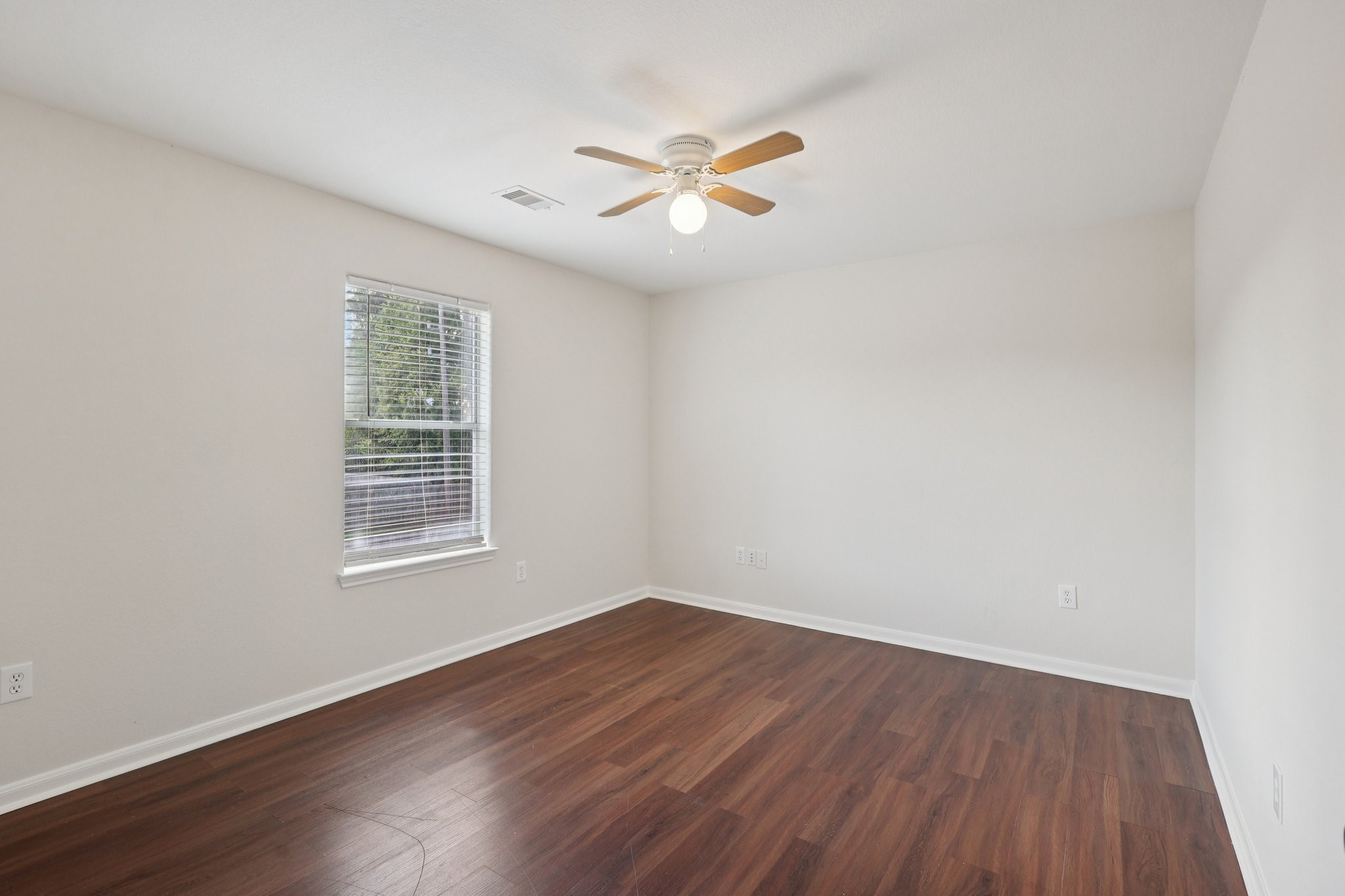4822 East Fairfax Village Circle Spring, TX 77373 - Photo 19 of 24 an empty room with wooden floor fan and windows