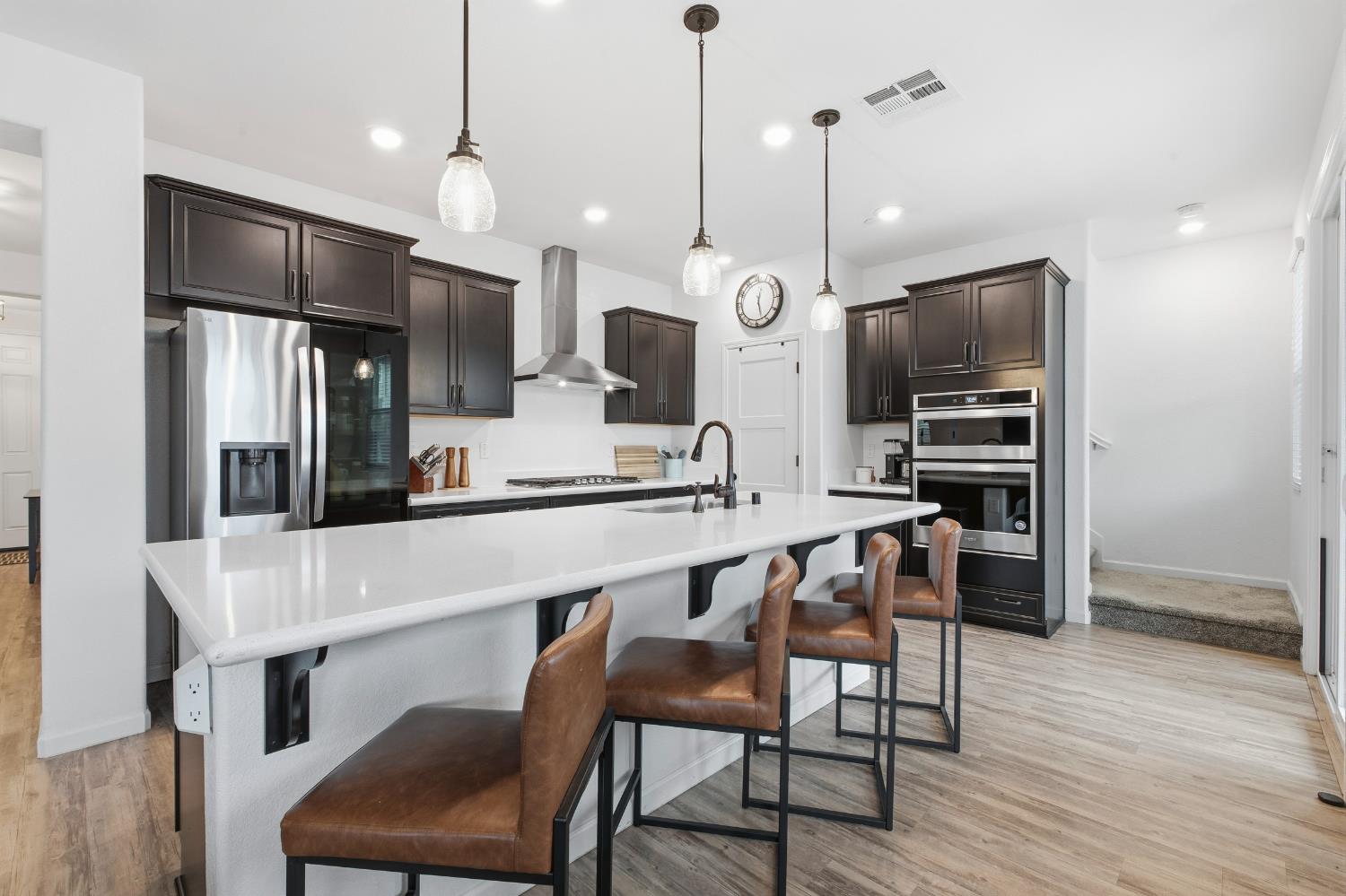 7240 Encore Way Roseville, CA 95747 - Photo 3 of 52 a kitchen with stainless steel appliances a dining table chairs refrigerator and microwave