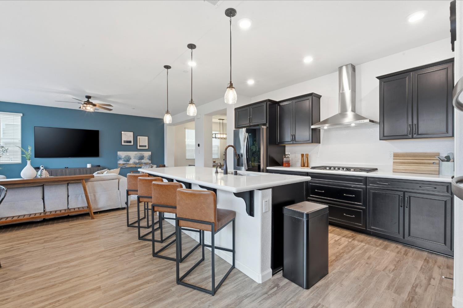 7240 Encore Way Roseville, CA 95747 - Photo 9 of 52 a kitchen with stainless steel appliances granite countertop a stove top oven a sink dishwasher a dining table and chairs with wooden floor