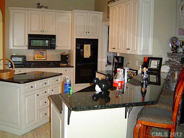 2626 Medlin Road Monroe, NC 28112 - Photo 12 of 16 a kitchen with granite countertop a sink stove and cabinets