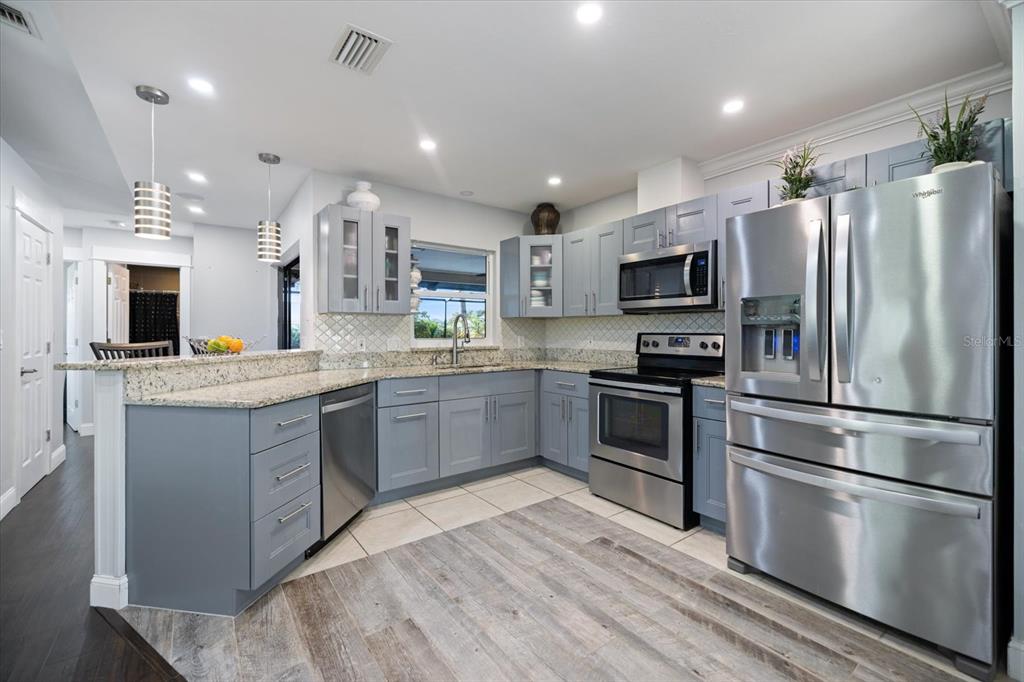 1627 Del Monte Court Venice, FL 34293 - Photo 14 of 78 a kitchen with kitchen island a counter top space stainless steel appliances and cabinets
