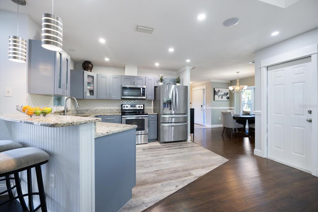 1627 Del Monte Court Venice, FL 34293 - Photo 15 of 78 a kitchen with stainless steel appliances kitchen island granite countertop a refrigerator and a stove top oven