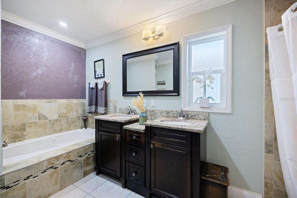 1627 Del Monte Court Venice, FL 34293 - Photo 23 of 78 a bathroom with a granite countertop sink a mirror and a bathtub