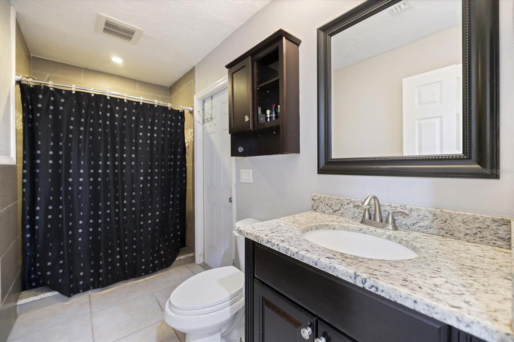 1627 Del Monte Court Venice, FL 34293 - Photo 29 of 78 a bathroom with a granite countertop sink toilet and shower