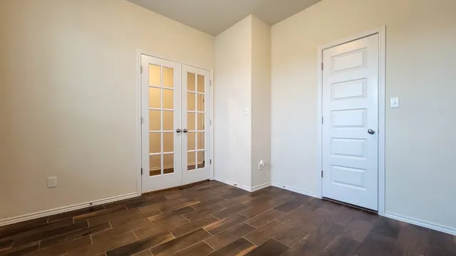 an empty room with wooden floor and cabinet