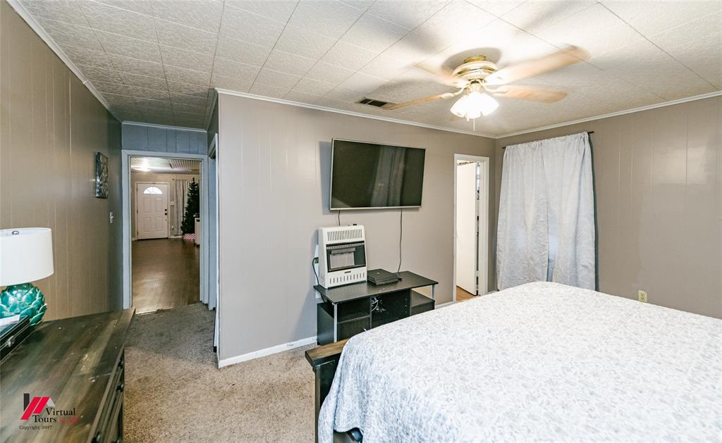 214 Ellis Drive Minden, LA 71055 - Photo 18 of 30 Bedroom featuring heating unit, carpet, ceiling fan, crown molding, and wooden walls