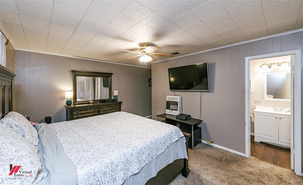 214 Ellis Drive Minden, LA 71055 - Photo 19 of 30 Bedroom with carpet flooring, a ceiling fan, ensuite bathroom, wooden walls, and heating unit