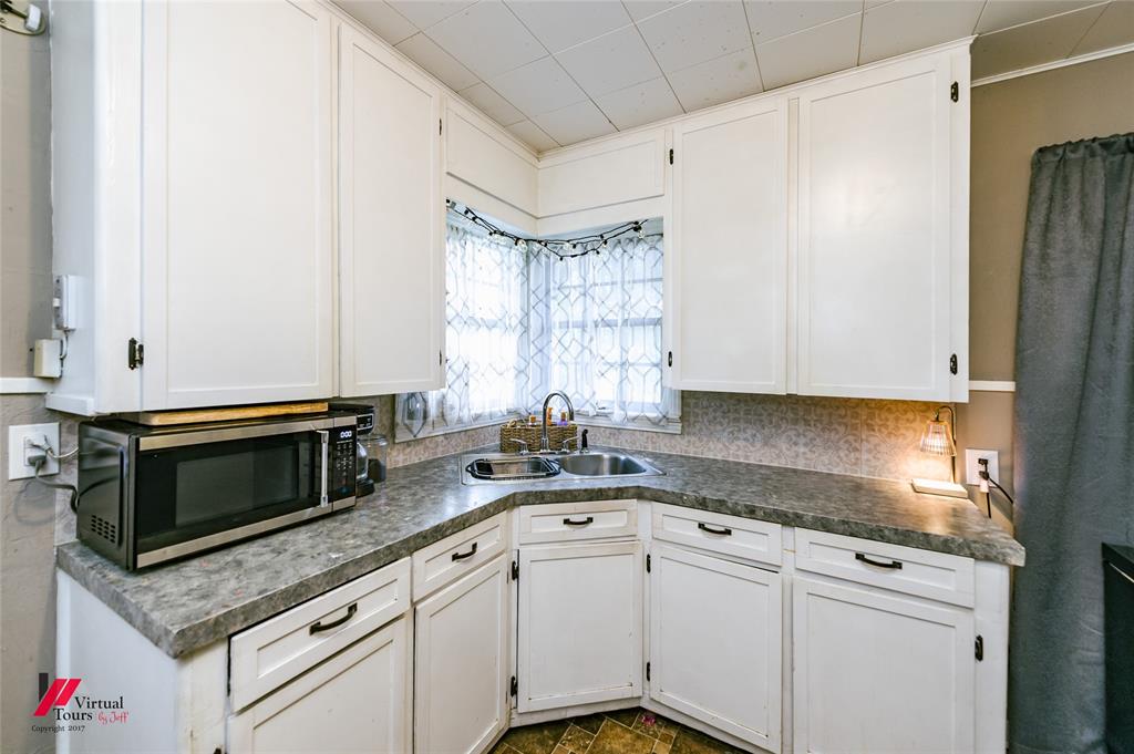 214 Ellis Drive Minden, LA 71055 - Photo 21 of 30 Kitchen featuring stainless steel microwave, white cabinetry, and dark countertops