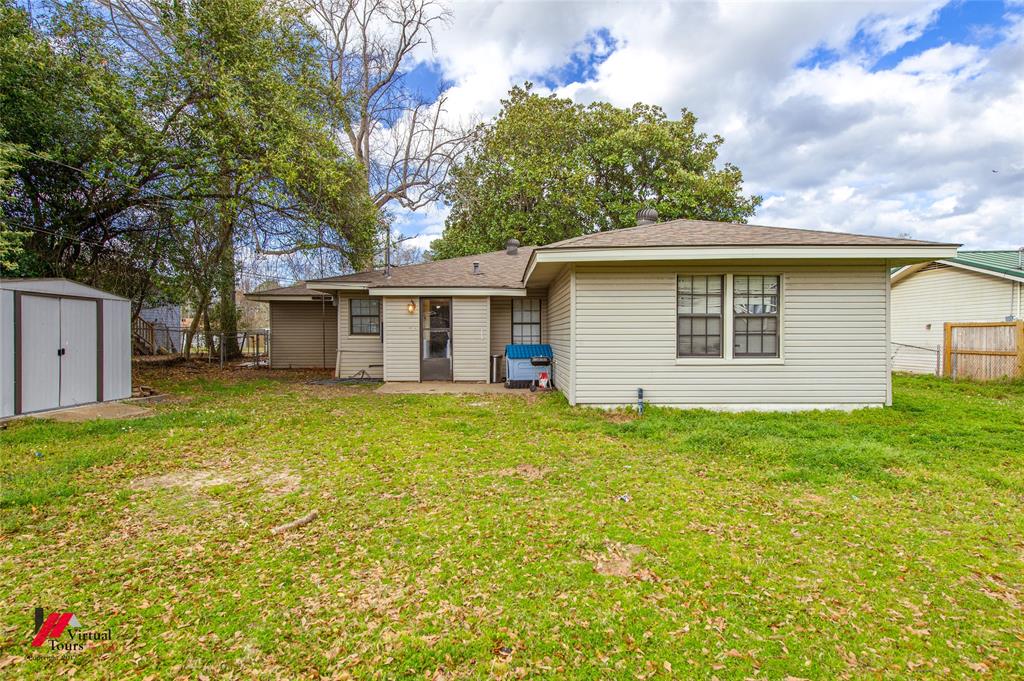 214 Ellis Drive Minden, LA 71055 - Photo 26 of 30 Back of property with a fenced backyard, a shed, roof with shingles, and a patio area