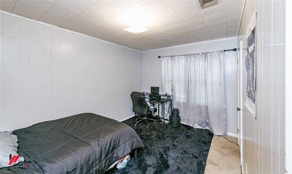 214 Ellis Drive Minden, LA 71055 - Photo 10 of 30 Bedroom featuring carpet floors, an office area, and wood walls