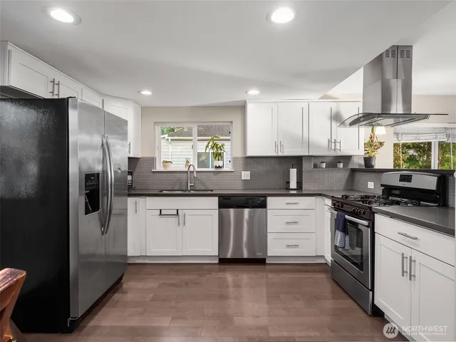 a kitchen with stainless steel appliances granite countertop a stove a sink and a refrigerator