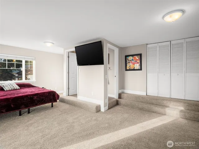 a spacious bedroom with a bed and a flat screen tv