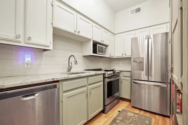 a kitchen with stainless steel appliances granite countertop a refrigerator sink and cabinets
