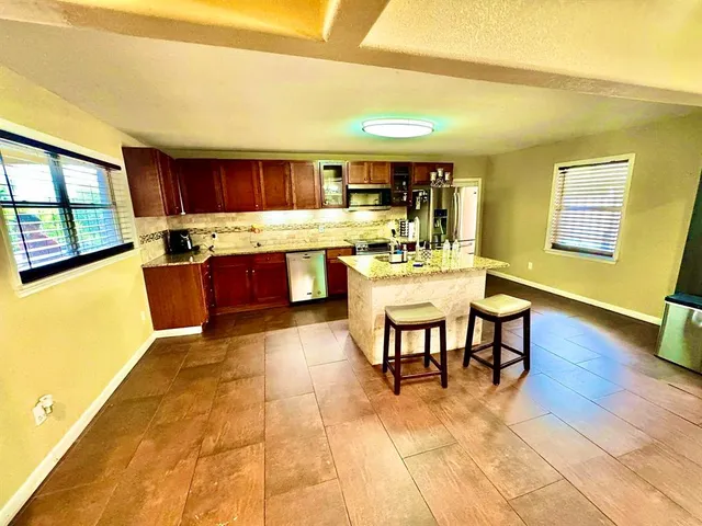 a kitchen with a table chairs and wooden floor