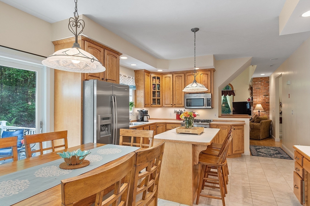 169 Narrows Road Westminster, MA 01473 - Photo 9 of 41 a kitchen with stainless steel appliances a dining table chairs a refrigerator and chandelier
