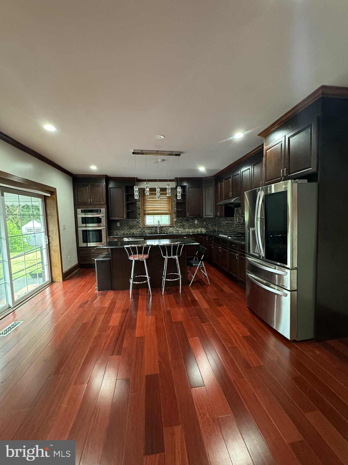 330 Sanger Street Philadelphia, PA 19120 - Photo 8 of 18 a kitchen with stainless steel appliances wooden floor and large window