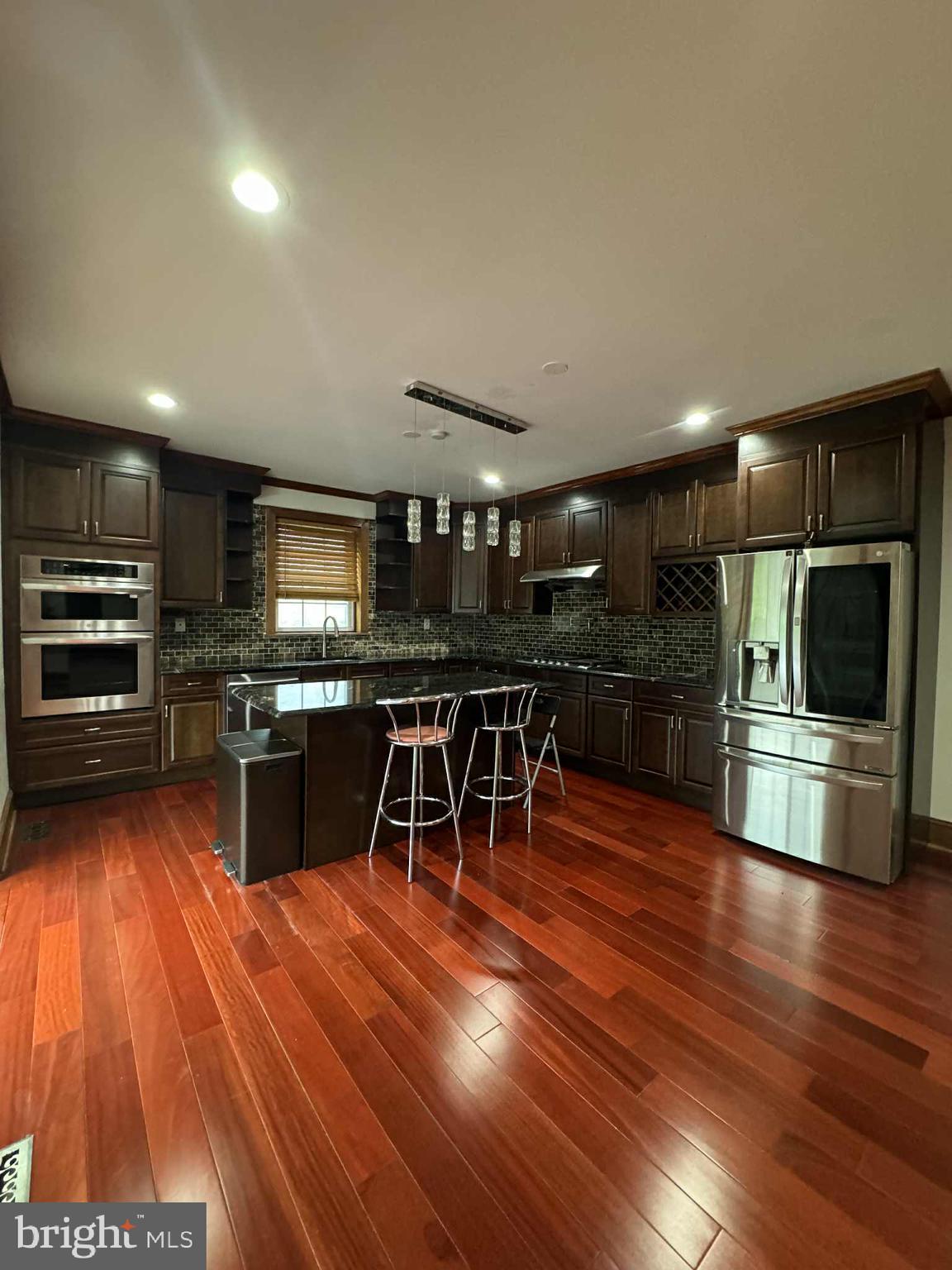 330 Sanger Street Philadelphia, PA 19120 - Photo 10 of 18 a kitchen with stainless steel appliances wooden floor and large counter top space