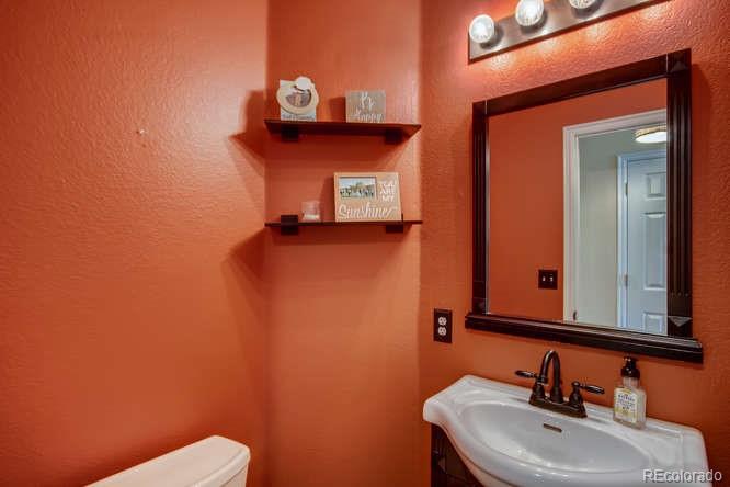 9629 Sydney Lane Highlands Ranch, CO 80130 - Photo 16 of 34 a bathroom with a toilet sink and mirror