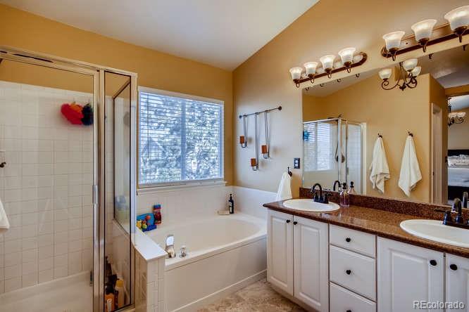 9629 Sydney Lane Highlands Ranch, CO 80130 - Photo 22 of 34 a bathroom with a tub a sink and a mirror