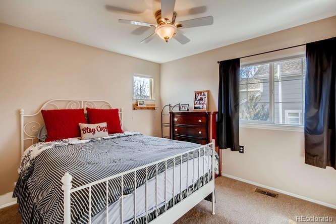 9629 Sydney Lane Highlands Ranch, CO 80130 - Photo 23 of 34 a bedroom with a large bed and a chandelier