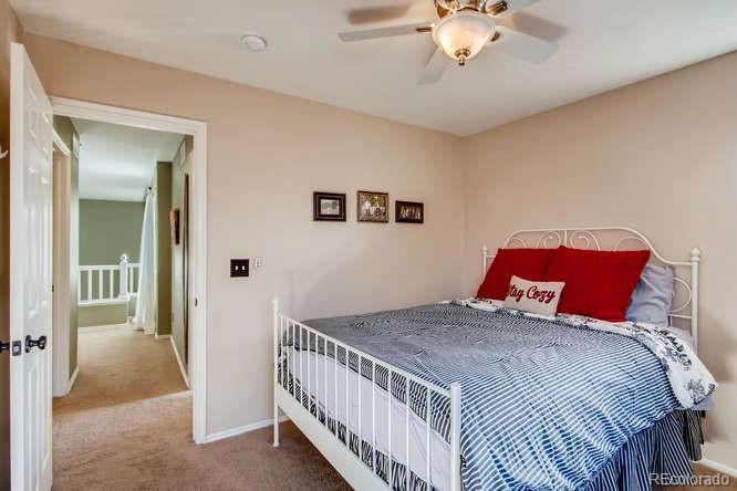 9629 Sydney Lane Highlands Ranch, CO 80130 - Photo 24 of 34 a bedroom with a large bed and a chandelier