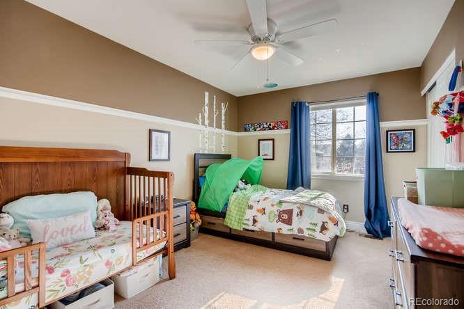 9629 Sydney Lane Highlands Ranch, CO 80130 - Photo 28 of 34 a bedroom with a bed and a chandelier