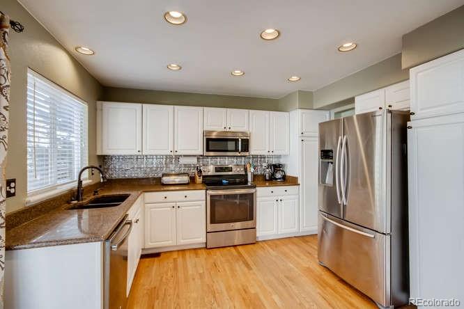 9629 Sydney Lane Highlands Ranch, CO 80130 - Photo 10 of 34 a kitchen with a refrigerator sink and microwave