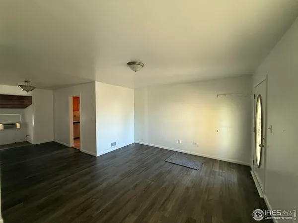 an empty room with wooden floor and closet