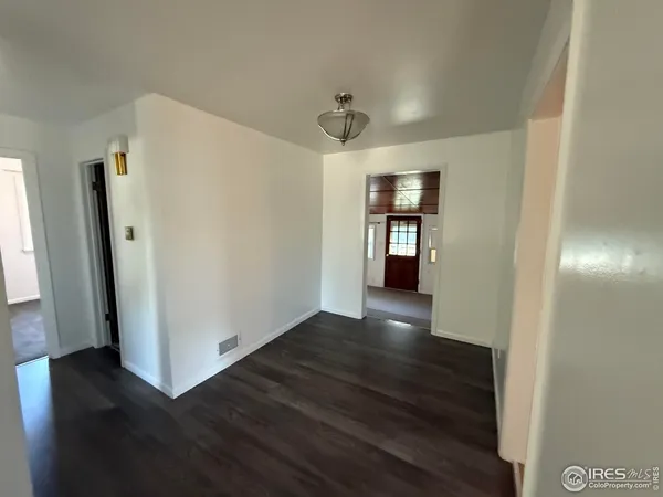 a view of a kitchen with wooden floor and a refrigerator