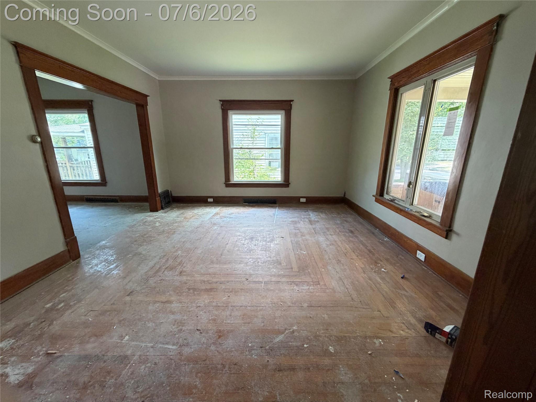 808 Division Street Owosso, MI 48867 - Photo 11 of 25 Hardwood flooring with herringbone pattern, crown molding, and original wood trim