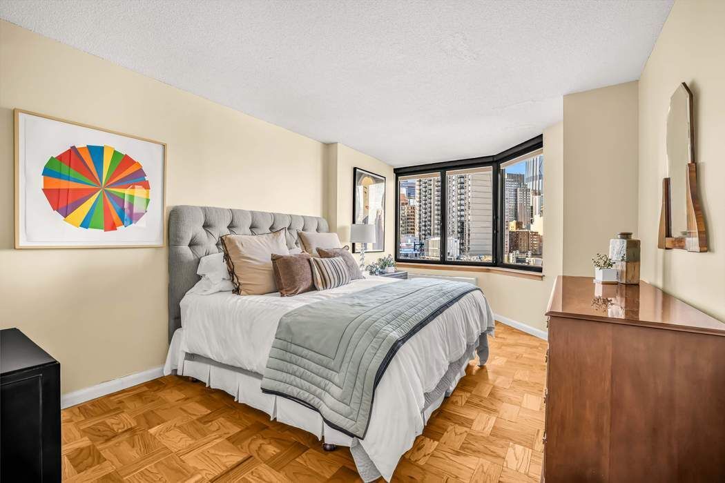 415 East 37th Street, Unit 21J Manhattan, NY 10016 - Photo 4 of 14 a spacious bedroom with a large bed and a large window