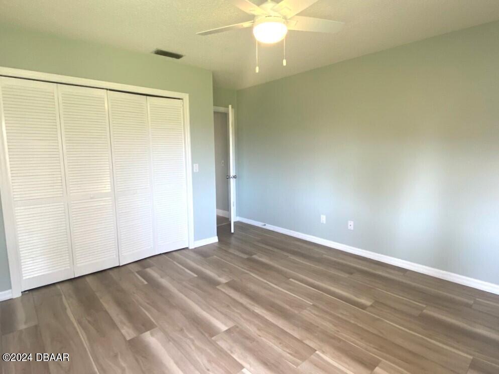 12 Julie Drive Ormond Beach, FL 32176 - Photo 19 of 24 a view of an empty room with wooden floor and a window